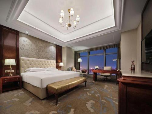 a large bedroom with a bed and a piano at Dongwu New Century Grand Hotel Huzhou in Huzhou