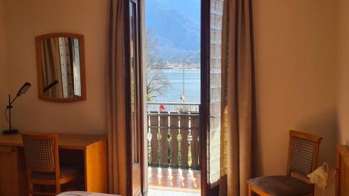 a door to a balcony with a view of the water at Bioledro - Casa Lena in Mezzolago