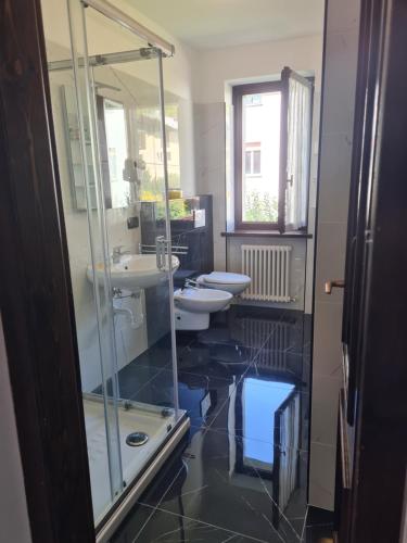a bathroom with two sinks and a glass shower at Bioledro - Casa Lena in Mezzolago