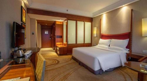 a bedroom with a large white bed in a room at Ocean Spring Metropark Hotel Zhuhai in Zhuhai