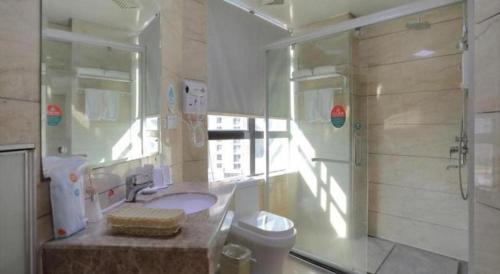 a bathroom with a shower and a sink and a toilet at GreenTree Inn Jieyang North Linjiang Road Express Hotel in Jieyang