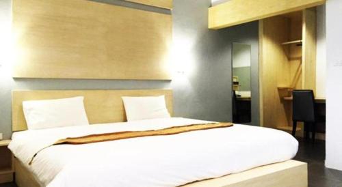 a bedroom with a large white bed in a room at NH Elegant Hotel in Sakon Nakhon