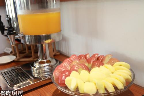 a glass bowl of fruit next to a glass of orange juice at Hotel Lohas in Hualien City