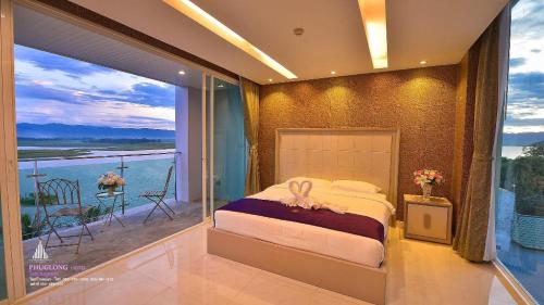 a bedroom with a bed with a view of the ocean at Phuglong Hotel in Phayao