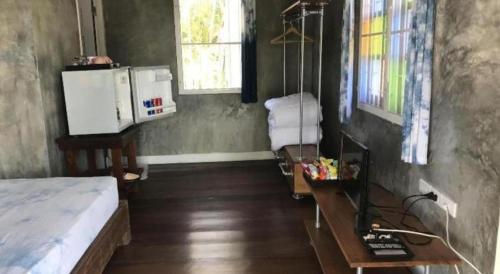 a room with a bed and a table and a desk at OYO 769 Ban Thassanee in Chiang Mai