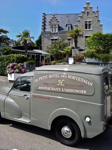an old gray van parked in front of a building at Le Petit Hôtel des Hortensias in La Trinité-sur-Mer