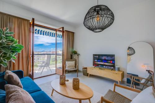 un salon avec un canapé bleu et une télévision dans l'établissement Lovely Apartment - 5min From Beach - Happy Rentals, à Juan-les-Pins