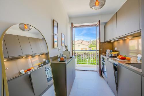 - une grande cuisine avec une grande fenêtre offrant une vue dans l'établissement Lovely Apartment - 5min From Beach - Happy Rentals, à Juan-les-Pins