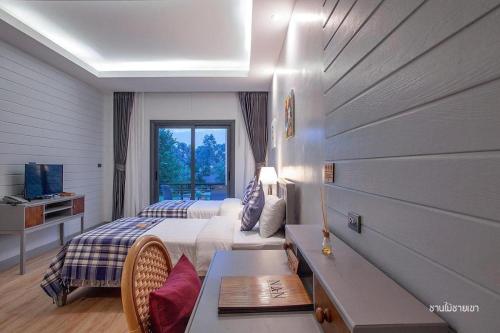 ein Hotelzimmer mit einem Bett und einem Fenster in der Unterkunft Nan Boutique Resort in Ban Hua Wiang Nua