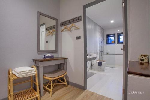 ein Badezimmer mit einem Waschtisch, einem Spiegel und einem Waschbecken in der Unterkunft Nan Boutique Resort in Ban Hua Wiang Nua