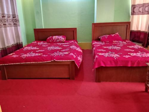 two beds in a room with pink sheets at Hotel Guest House Saydabad in Dhaka