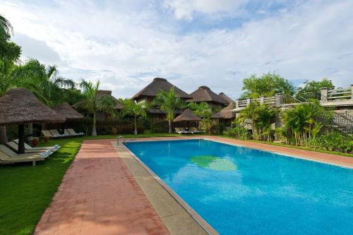 a swimming pool in front of a resort at Sparsa Resort Thiruvanamalai in Tiruvannāmalai