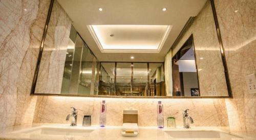 a bathroom with two sinks and a large mirror at Shanghai Fuyue Hotel in Shanghai