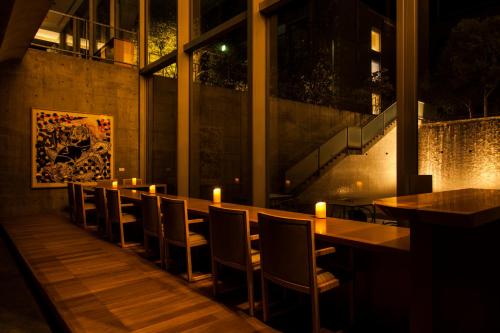 a row of tables in a restaurant with candles on them at SETOUCHI RETREAT by Onko Chishin in Matsuyama