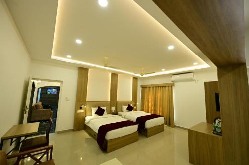 a hotel room with two beds and a window at North Fort Regency in Cochin