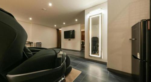 a living room with a couch and a flat screen tv at Cheongju Maryjane Hotel in Cheongju