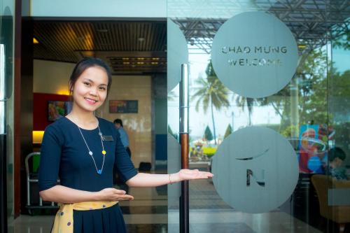 a woman standing in front of a glass door at Novotel Nha Trang in Nha Trang