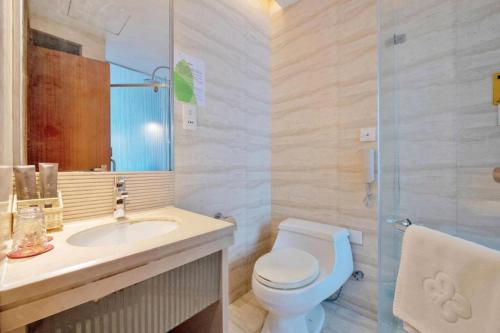 a bathroom with a toilet and a sink and a shower at Golden Central Hotel Shenzhen in Shenzhen