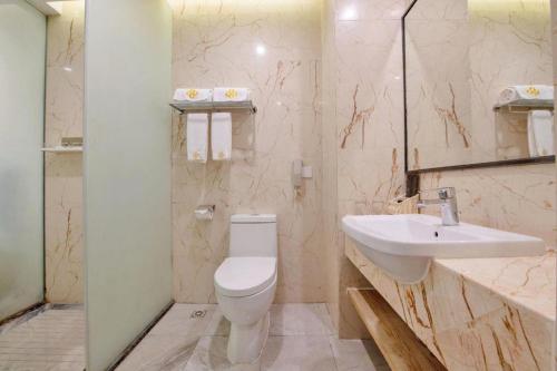 a bathroom with a toilet and a sink at Golden Central Hotel Shenzhen in Shenzhen