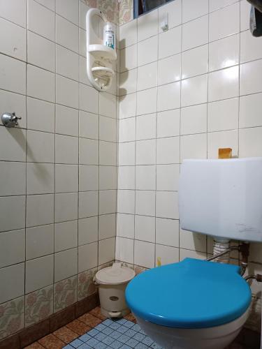 a bathroom with a toilet with a blue lid at Samadhi in Tigre