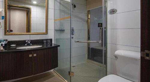 a bathroom with a shower and a toilet and a sink at Zhongshan Hui Quan Hotel in Zhongshan