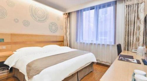 une chambre avec un lit, un bureau et une fenêtre dans l'établissement GreenTree Inn Beijing Tongzhou District Ciqu Subway Station Express Hotel, à Pékin