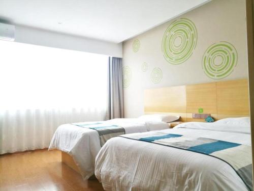 a room with three beds and a window at GreenTree Inn Yancheng Yandu District Hongxing Macalline Century Avenue in Yancheng