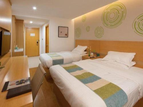 a hotel room with two beds and a bathroom at GreenTree Inn Yancheng Yandu District Hongxing Macalline Century Avenue in Yancheng