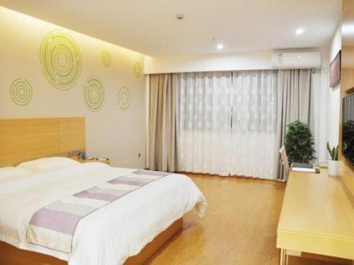 a bedroom with a large bed and a large window at GreenTree Inn Yancheng Yandu District Hongxing Macalline Century Avenue in Yancheng