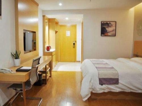 a hotel room with a bed and a desk and a desk at GreenTree Inn Yancheng Yandu District Hongxing Macalline Century Avenue in Yancheng