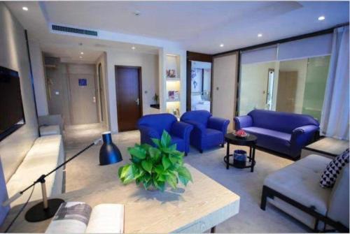 a living room with blue couches and a couch at Kyriad Marvelous Hotel Xiangyin Bus Station in Xiangyin