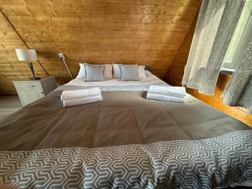 a bedroom with a large bed in a wooden room at Zhyluu Suu Resort BozUchuk in Novovoznesenovka