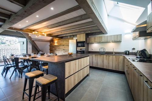 eine große Küche mit einer langen Insel mit einem Tisch in der Unterkunft Duplex in Albiez-Montrond with terrace in Albiez-Montrond