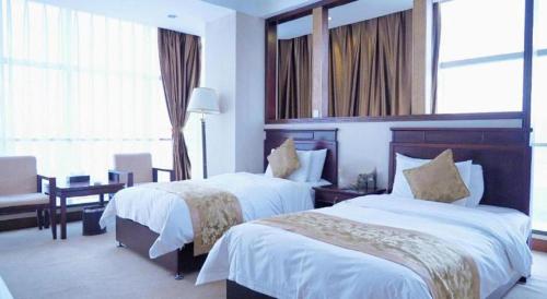 a hotel room with two beds and a desk at Datong Tiangui International Hotel in Datong
