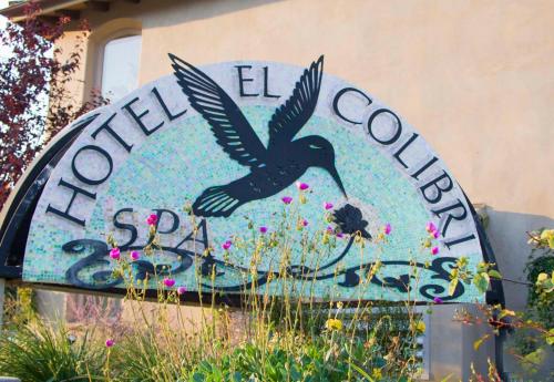a sign for a flower garden with a bird at El Colibri Hotel & Spa in Cambria