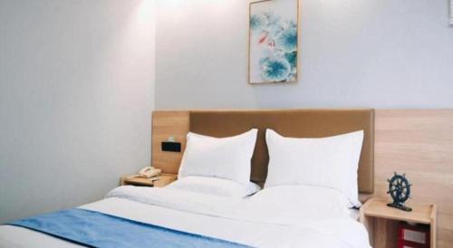 a bedroom with a bed with two white pillows at GreenTree Inn Jiaxing Tongxiang Tudian Express Hotel in Jiaxing