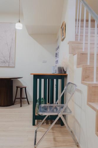 a chair in a room with a staircase at Boléro Homestay I 鄰近花園夜市 in Tainan
