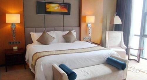 a bedroom with a large white bed and a couch at Zhangjiagang Zhonglian GDH International Hotel in Zhangjiagang