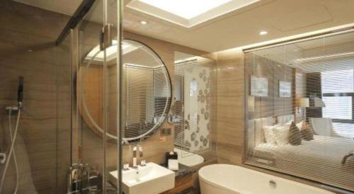 a bathroom with a tub and a sink and a mirror at Zhangjiagang Zhonglian GDH International Hotel in Zhangjiagang