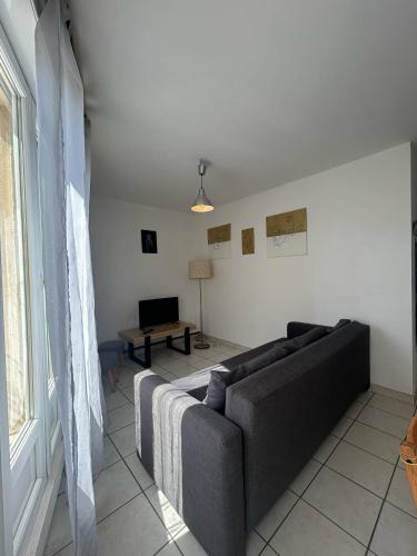 un salon avec un canapé et une fenêtre dans l'établissement Le Marceau, à Mèze