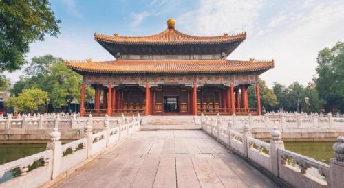 a large building with a bridge in a park at Jianguo Garden Hotel in Beijing