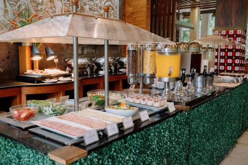 a buffet line with food and drinks in a restaurant at Astagina Resort Villa and Spa in Legian