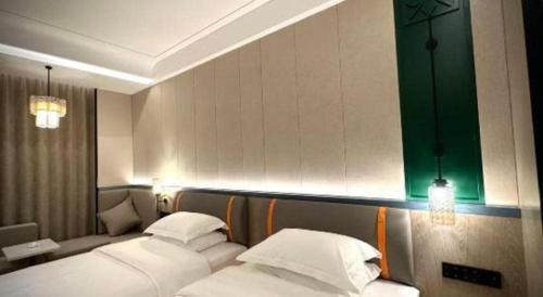 a hotel room with two beds with white pillows at Tianrun International Hotel in Dunhuang