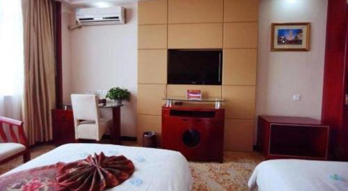 a hotel room with a bed and a flat screen tv at Tianrun International Hotel in Dunhuang