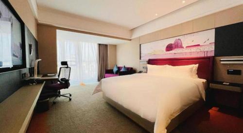 a hotel room with a large bed and a television at Hampton by Hilton Zhuhai Doumen in Zhuhai