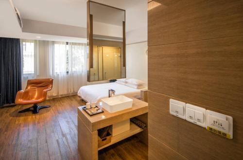 a bathroom with a bed and a sink and a mirror at Xiamen Gulangyu Heitan Hotel in Xiamen