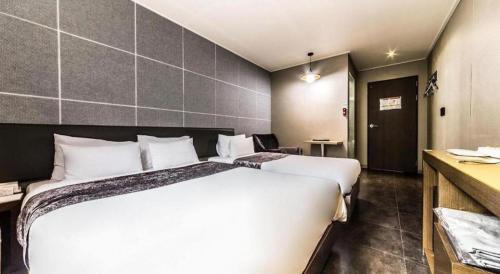 a bedroom with a large white bed in a room at Line Plus Hotel in Gimpo