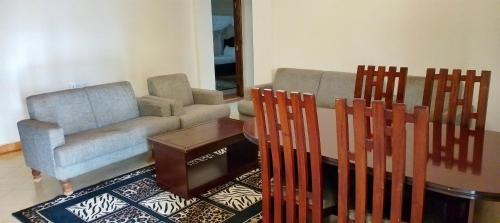 a living room with a couch and a table and chairs at Elboran resort and spa in Isiolo