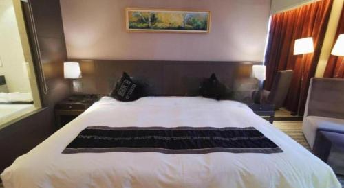 a hotel room with a bed and a couch at Putian Depo Hotel in Putian