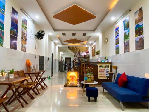 a living room with a blue couch and a table and chairs at Gold Stone Hoi An Homestay in Hoi An